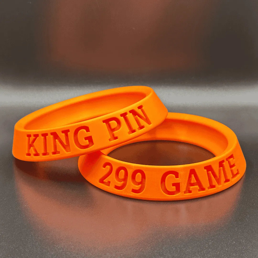 Two orange wristbands with 'KING PIN' and '299 GAME' text on a reflective surface.