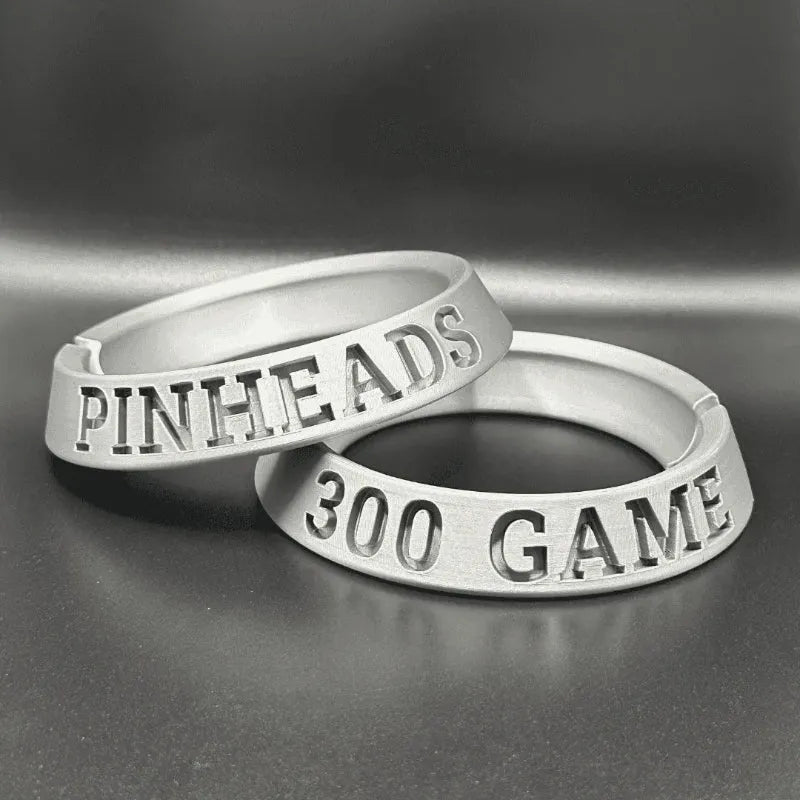 Two silver rings with engraved text on a gray background