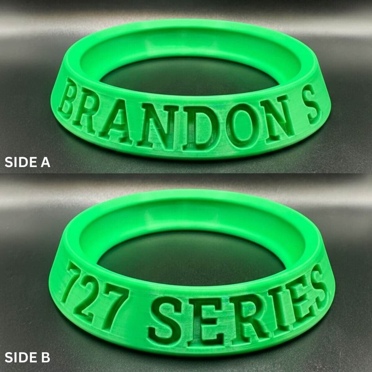 Two green rubber bands with text on a metallic surface
