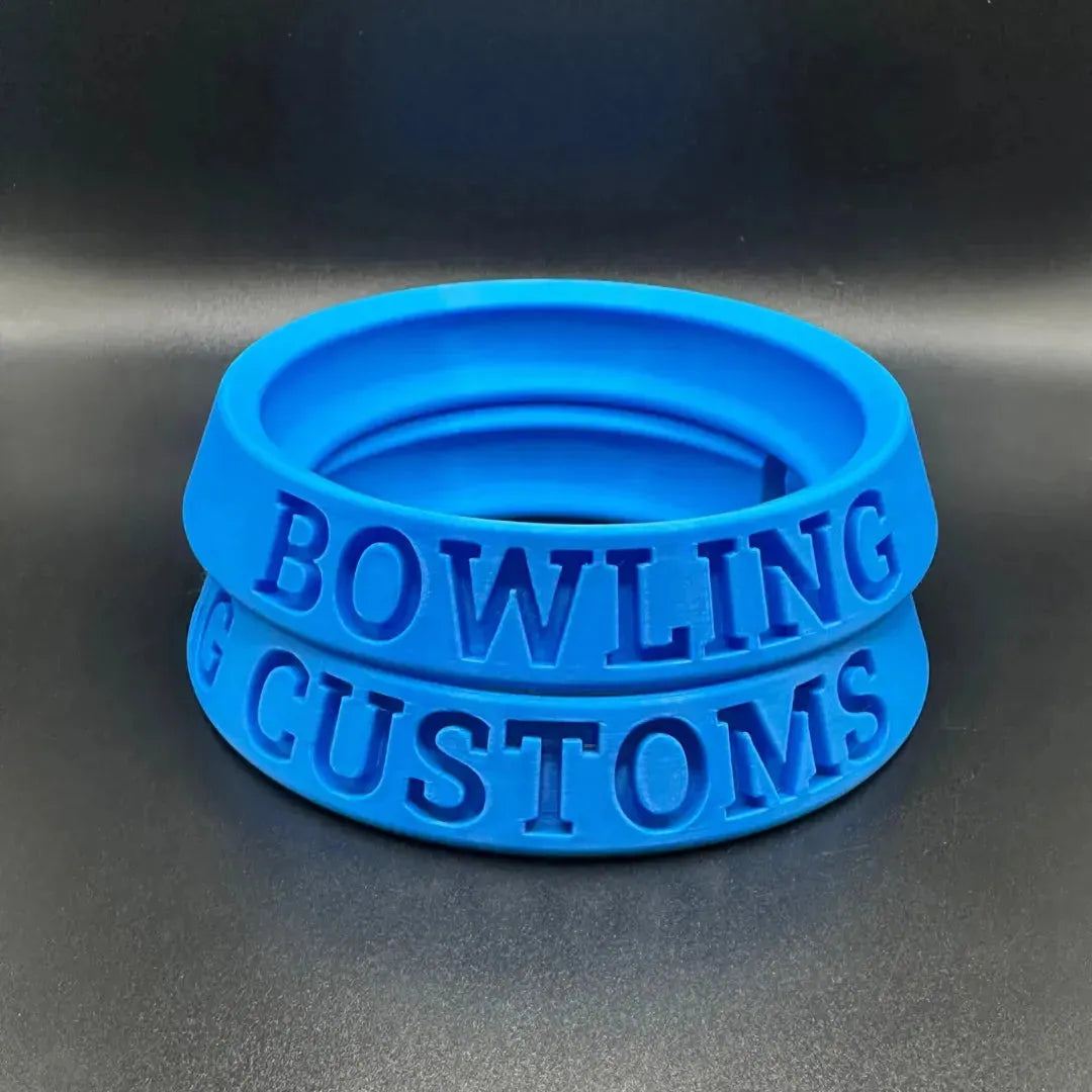 Blue rubber bands with 'Bowling Customs' text on a metallic surface