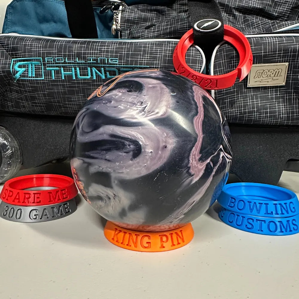 Bowling ball with accessories on a white surface, including a bag and other items.