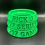 Stack of green wristbands with engraved text on a dark background