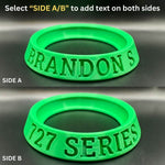 Green silicone ring with text on two sides on a dark background