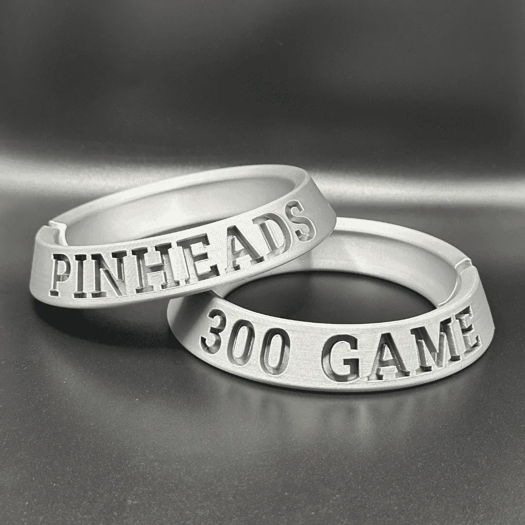 Two silver rings with engraved text on a gray background