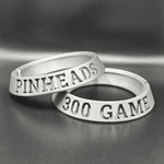 Two silver rings with engraved text on a gray background