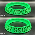Two green rubber bands with text on a metallic surface